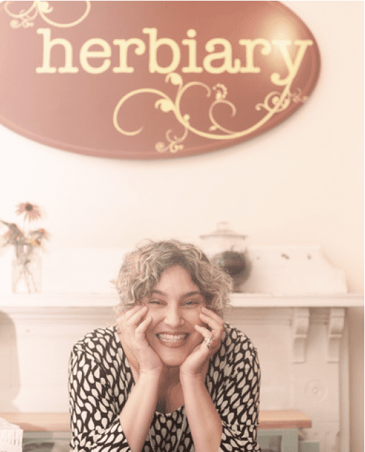 Maia in front of Herbiary's shops sign